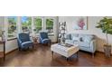 Bright living room with hardwood floors, a bay window, and stylish furniture, creating a comfortable and inviting space at 3973 S Joplin Way, Aurora, CO 80013