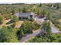 Beautiful home with dark roof trim surrounded by green trees, accessed by a paved driveway at 922 W Wolfensberger Rd, Castle Rock, CO 80109