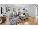 Bright living room featuring hardwood floors, large windows, and a comfortable sectional sofa, perfect for relaxation at 9826 E 27Th Dr, Denver, CO 80238
