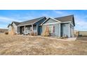 A single-story blue house features a charming facade and neatly landscaped yard at 253 E 8Th Ave, Byers, CO 80103