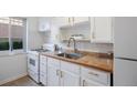 Clean kitchen featuring white cabinets, tile backsplash, modern sink and faucet, and gas range at 1454 Jersey St # 2, Denver, CO 80220