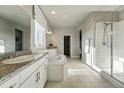 Spacious bathroom with double vanity, soaking tub, walk-in shower, and neutral tile flooring at 4825 Basalt Ridge Cir, Castle Rock, CO 80108