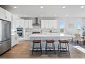 Bright, open kitchen featuring stainless steel appliances, a large island with seating, and white cabinetry at 4825 Basalt Ridge Cir, Castle Rock, CO 80108