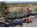 Exterior aerial view of a multi-story building with balconies, landscaping, and a parking lot at 381 S Ames St # E305, Lakewood, CO 80226