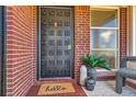 Inviting front porch with decorative door, 'hello' doormat, potted plants, and chair at 5975 S Milwaukee Way, Centennial, CO 80121