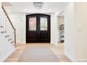 Elegant foyer with wood floors, features a striking dark wood double door entrance and stylish staircase at 38 Sedgwick Dr, Cherry Hills Village, CO 80113