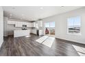 Open-concept living room and kitchen area with wood flooring and bright, natural light at 19079 E 94Th Pl, Commerce City, CO 80022