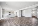 Open-concept living area with kitchen, stainless appliances, island, and hardwood floors at 19079 E 94Th Pl, Commerce City, CO 80022