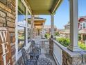 Relaxing front porch featuring stone pillars and a charming seating area overlooking the community at 13638 Garfield St # C, Thornton, CO 80602