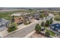 Aerial view of a neighborhood with a golf course and a pond nearby, showcasing the home's location at 2190 Coyote Creek Dr, Fort Lupton, CO 80621