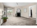 Bright living room featuring plush carpeting, a cozy fireplace, and a sliding glass door to the outdoor space at 5300 E Cherry Creek South Dr # 324, Denver, CO 80246