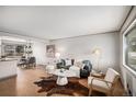 Bright and airy living room featuring neutral decor, hardwood floors, and a large window overlooking the street at 6576 S Lincoln St, Centennial, CO 80121