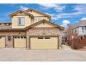 Exterior view of a townhome featuring a stone facade and multiple garage doors at 6702 S Winnipeg Cir # 101, Aurora, CO 80016