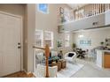 Inviting living area with high ceilings, featuring a staircase and seamless flow to the dining space at 6702 S Winnipeg Cir # 101, Aurora, CO 80016