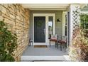 Welcoming front porch with stone accents, decorative seating, and a charming entrance door at 9265 Buttonhill Ct, Highlands Ranch, CO 80130