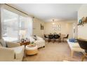 Bright living room featuring a neutral palette, plush seating, and an adjacent dining area at 2964 S Akron St, Denver, CO 80231