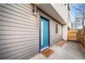 Modern home exterior featuring a vibrant blue door, gray siding, and fresh landscaping at 1810 Julian St # 105, Denver, CO 80204