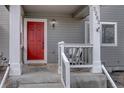 Inviting front porch with a bright red door, classic white columns, and a cozy seating area at 2283 S Bannock St, Denver, CO 80223