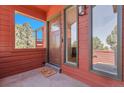 Front door entrance showcasing a covered porch with windows and a stylish doormat at 10991 Expedition, Littleton, CO 80125