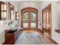 Bright foyer with hardwood floors, arched double doors, and elegant lighting fixtures and area rug at 113 Elk Crossing Ln, Evergreen, CO 80439