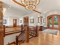 Elegant foyer featuring hardwood floors, a chandelier, staircase, and a view of the entrance and sitting area at 113 Elk Crossing Ln, Evergreen, CO 80439