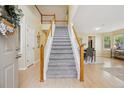 Bright foyer featuring hardwood floors, a staircase, and views into the dining area at 15597 E Dorado Ave, Centennial, CO 80015