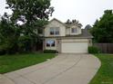 Traditional two-story home featuring a large driveway, attached two-car garage, and tidy landscaping at 13651 Silverton Dr, Broomfield, CO 80020