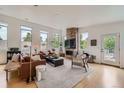 Bright living room with stone fireplace, hardwood floors and multiple windows showing outdoor views at 3850 Vallejo St, Denver, CO 80211
