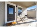 Cozy front porch with seating, a dark front door, and stylish decor at 2489 Alto St, Fort Lupton, CO 80621