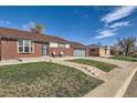 Charming brick home featuring a well-manicured lawn with inviting walkway at 7120 Galapago St, Denver, CO 80221