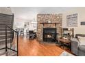Bright living room featuring hardwood floors, a fireplace, and staircase to upper level at 10298 W Dartmouth Ave, Lakewood, CO 80227