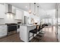 Open concept kitchen and living room with stainless steel appliances and island with seating at 2952 S Delaware St, Englewood, CO 80110