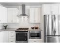 Close-up of the kitchen showcasing stainless steel appliances and white subway tile backsplash at 2952 S Delaware St, Englewood, CO 80110