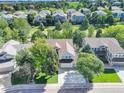 Residential neighborhood aerial view showcasing mature trees, well-maintained lawns, and a golf course in the distance at 10032 Astoria Ct, Lone Tree, CO 80124