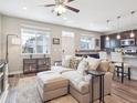 Open-concept living room flowing into the kitchen with hardwood floors and stylish furniture at 16611 E 119Th Ave # E, Commerce City, CO 80022