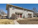 A daytime exterior view of a multi-Gathering home with light colored siding and red doors at 1922 S Oswego Way, Aurora, CO 80014