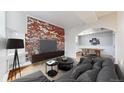 Cozy living room featuring exposed brick wall, hardwood floors and an open concept dining area at 108 W Byers Pl # G4, Denver, CO 80223