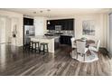 Well-lit kitchen with black cabinetry, stainless appliances, and an adjacent dining area at 10465 Evansville Cir, Parker, CO 80134
