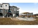 Exterior of modern townhomes showcasing a community patio and seating area at 2676 W 68Th Ave, Denver, CO 80221