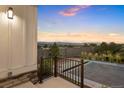 Backyard patio offering stunning sunset views of the surrounding landscape and retaining wall at 7022 Homeplace St, Castle Rock, CO 80108