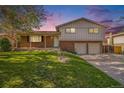 Charming two-story home featuring brick and siding, a covered porch, and a well-manicured lawn at 9345 W Iowa Pl, Lakewood, CO 80232