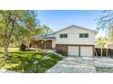 Traditional two-story home with brick accents, a covered porch, and a spacious front yard at 9345 W Iowa Pl, Lakewood, CO 80232