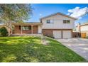 Charming two-story home featuring brick and siding, a covered porch, and a well-manicured lawn at 9345 W Iowa Pl, Lakewood, CO 80232