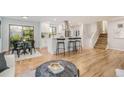 Open-concept living area featuring hardwood floors, kitchen with breakfast bar, and access to the backyard at 9345 W Iowa Pl, Lakewood, CO 80232