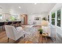 Comfortable living room with an open layout to the kitchen, featuring a plush rug and large windows at 11569 W 27Th Ave, Lakewood, CO 80215