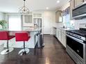 Modern kitchen with stainless steel appliances, gray cabinets, granite counters, and dark hardwood floors at 17908 E 54Th Ave, Denver, CO 80249