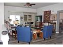 Open concept living room featuring wood floors, a ceiling fan, and a dining area at 7824 S Zante Ct, Aurora, CO 80016