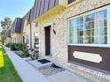 Charming townhome with brick facade, landscaped front yard, and walkway leading to the front door at 5677 S Lowell Blvd, Littleton, CO 80123