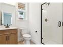 Modern bathroom featuring a sleek vanity, toilet, and walk-in shower with black trim at 8376 Cokedale Dr, Littleton, CO 80125
