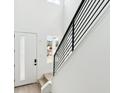 Bright stairwell with white walls, wood stairs, and black metal railing at 8376 Cokedale Dr, Littleton, CO 80125